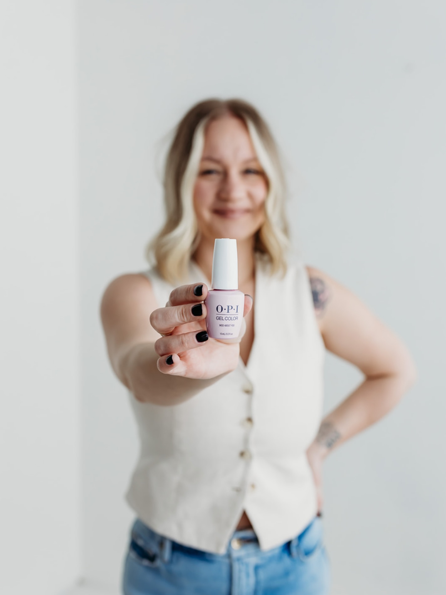 Nail technician at Nakd Nails holding OPI gel color polish