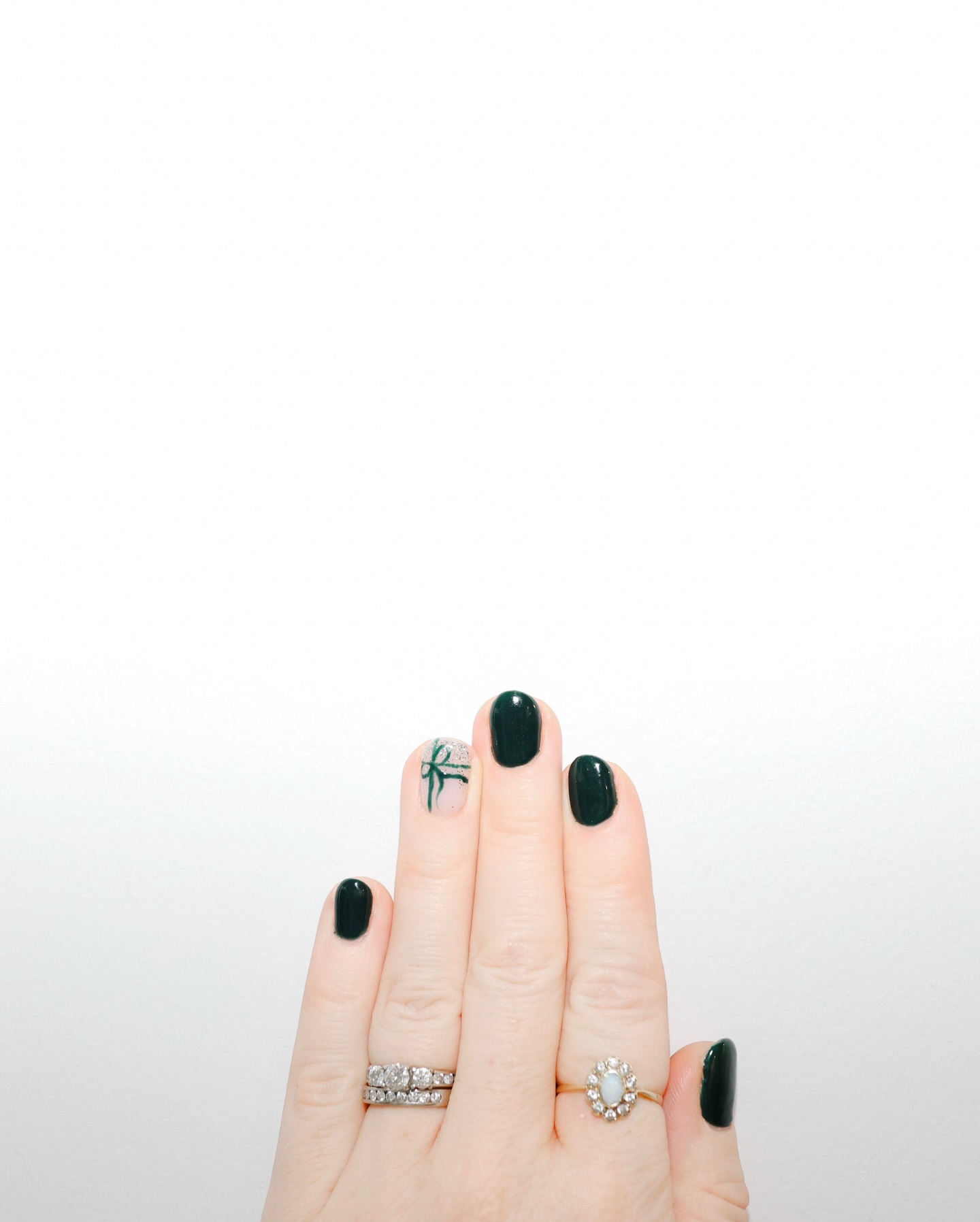 Dark green holiday nail design with ribbon detail