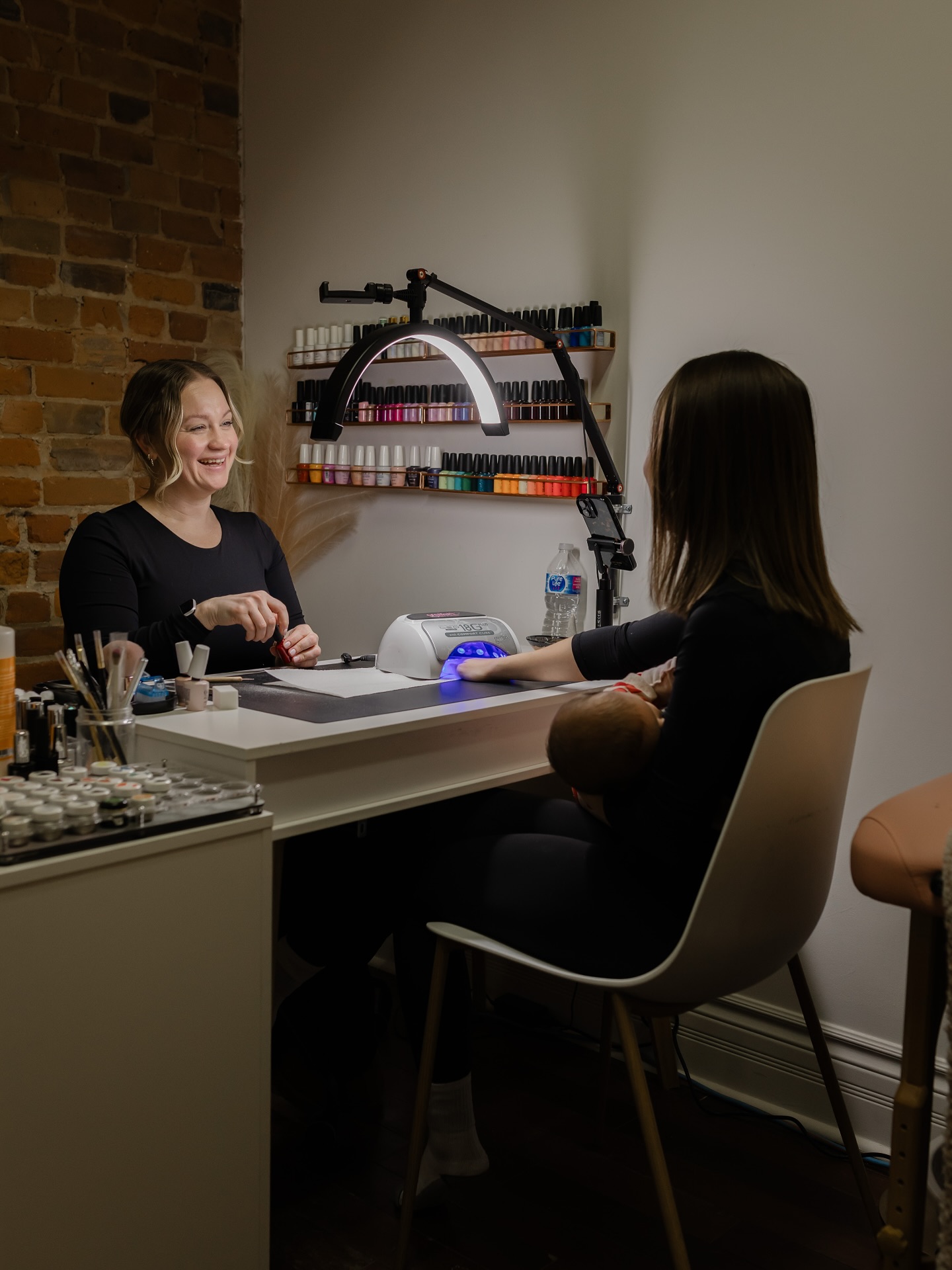 Nail artist at work with client at Nakd Nails studio